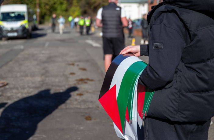 A Celtic fan holding Palestine flags
