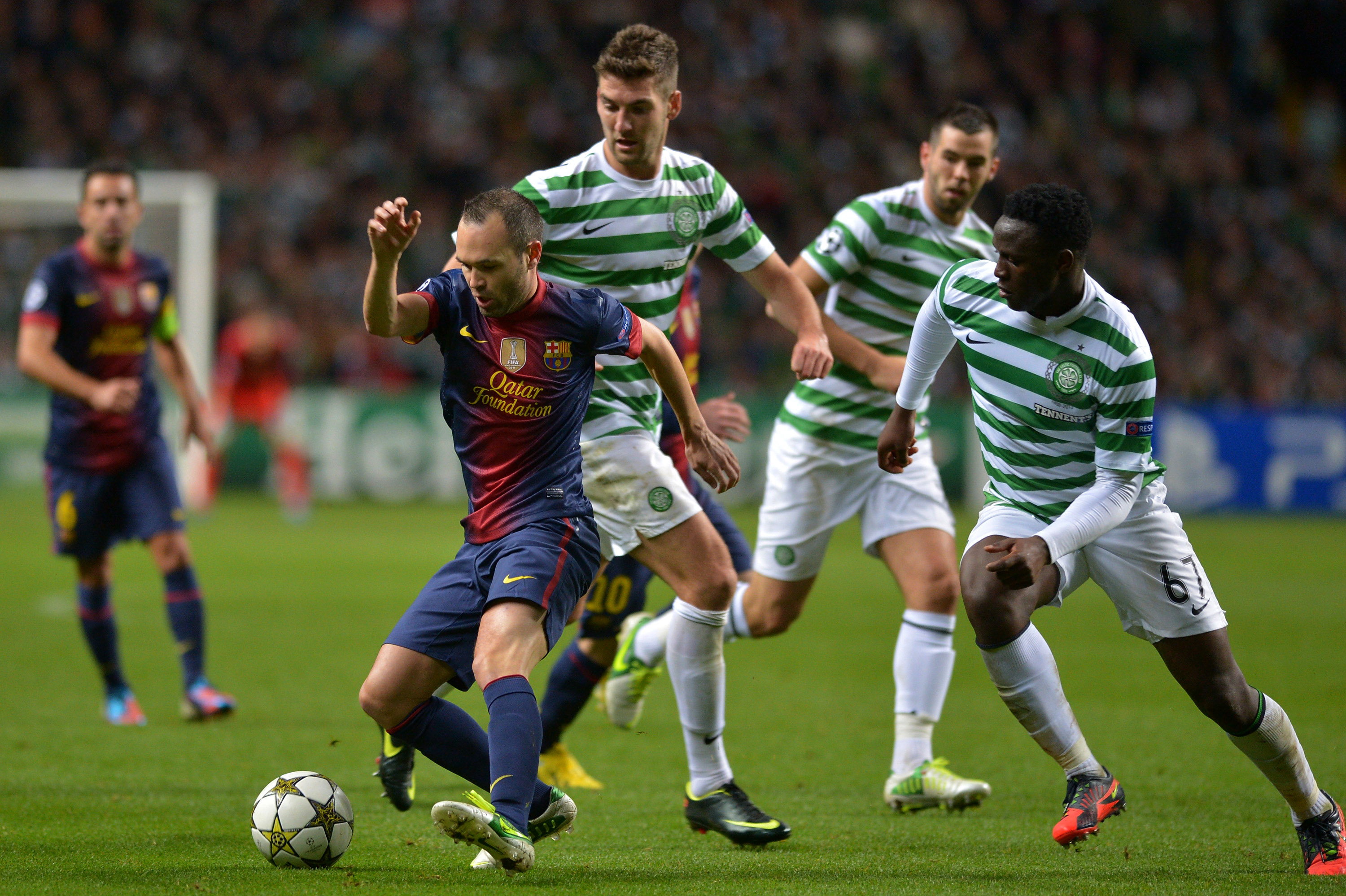 Charlie Mulgrew and Victor Wanyama of Celtic challenge Andres Iniesta