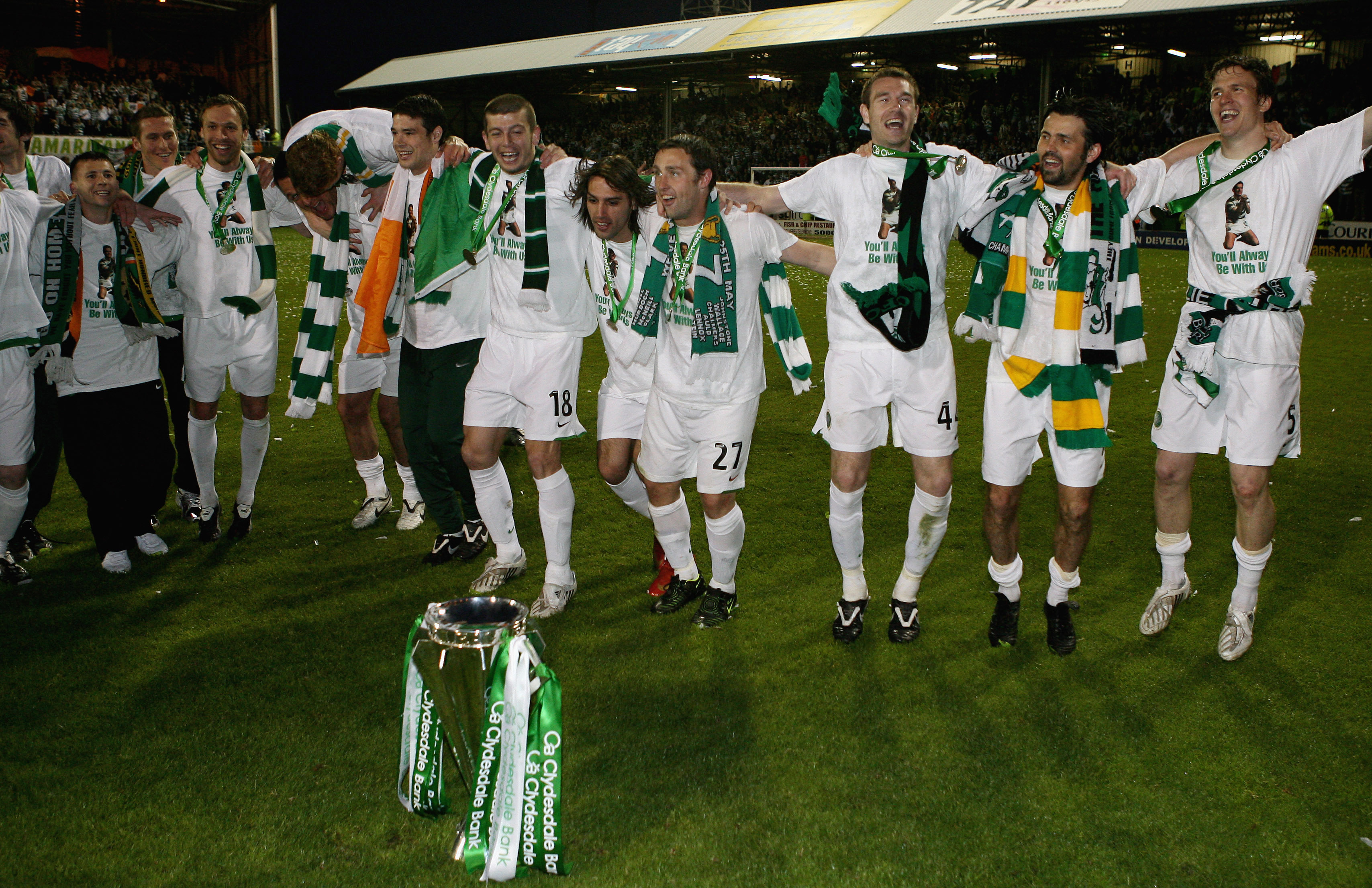 Celtic players dance around the Scottish Premier league trophy 