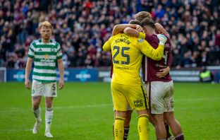 Hearts players celebrate as a dejected Liam Scales looks on