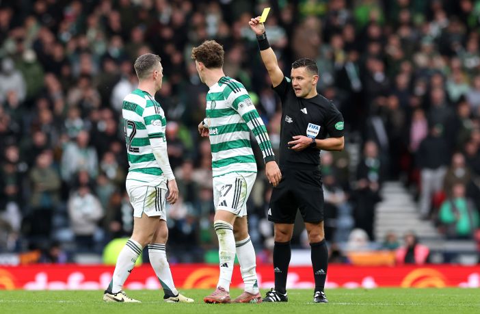 Referee Nick Walsh shows a yellow card to Arne Engels