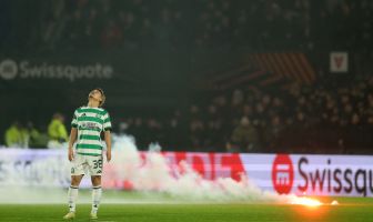 Daizen Maeda of Celtic reacts as a flare falls onto the pitch