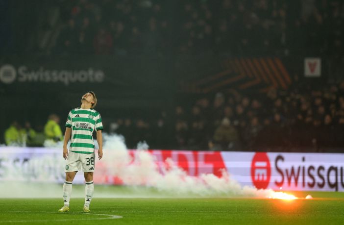 Daizen Maeda of Celtic reacts as a flare falls onto the pitch