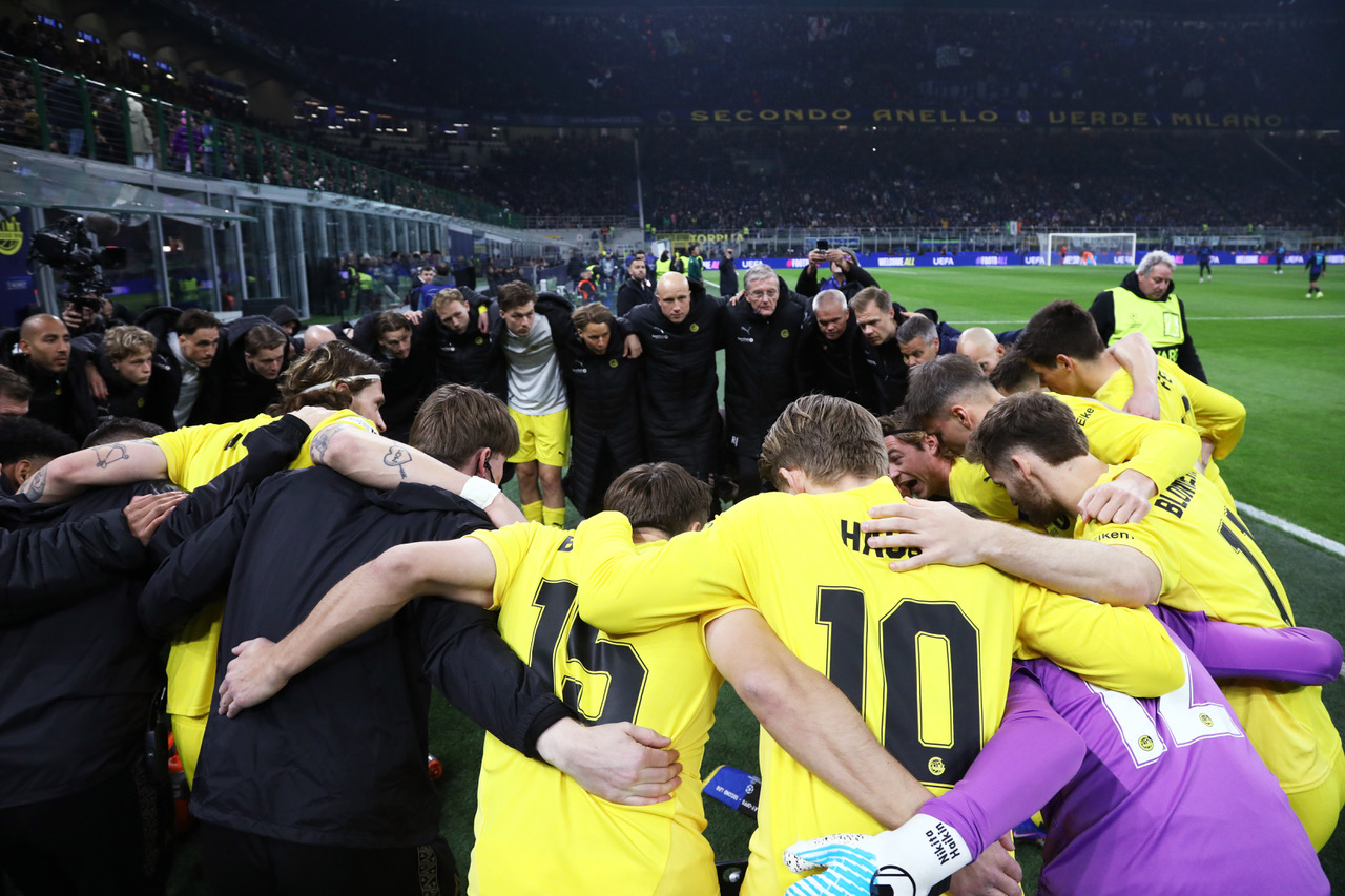 Bodo/Glimt players and coaching staff enter a huddle 