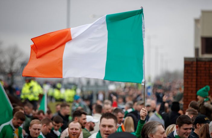A Celtic fan flies an Irish Tricolour on the way to Ibrox on Beautiful Sunday