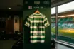 Celtic FC jersey in iconic green hoops hanging in stadium dressing room with natural lighting