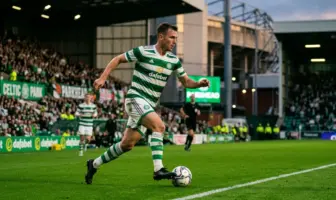 Celtic midfielder in green hooped kit controlling football at Celtic Park stadium