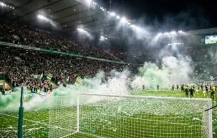 Celtic fans celebrate championship title win with green smoke and confetti at Paradise stadium