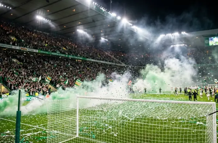 Celtic fans celebrate championship title win with green smoke and confetti at Paradise stadium