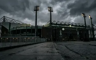 Celtic Park stadium exterior under moody grey skies symbolizing management departure and transition
