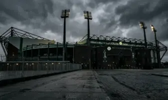 Celtic Park stadium exterior under moody grey skies symbolizing management departure and transition