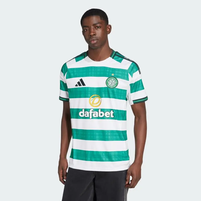 Celtic FC Adidas home shirt displayed on a model with green and white stripes.