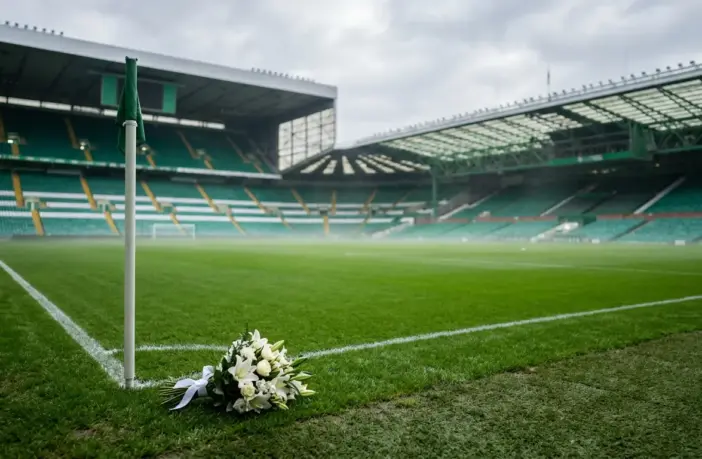 Empty Celtic Park stadium with memorial flowers on pristine green pitch under soft daylight