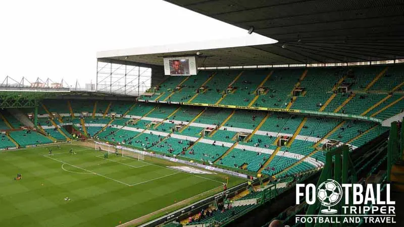 Interior view of Celtic Park stadium with empty stands and football pitch.