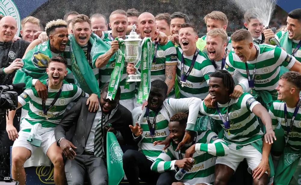 Celtic players celebrating with the Scottish Cup trophy after winning the match.