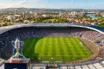 Hampden Park stadium on match day with trophy in foreground, Glasgow skyline visible