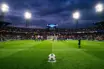 Football on penalty spot under stadium floodlights in dramatic title-deciding match atmosphere