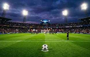 Football on penalty spot under stadium floodlights in dramatic title-deciding match atmosphere