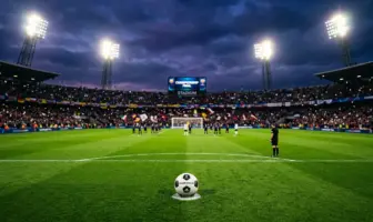 Football on penalty spot under stadium floodlights in dramatic title-deciding match atmosphere