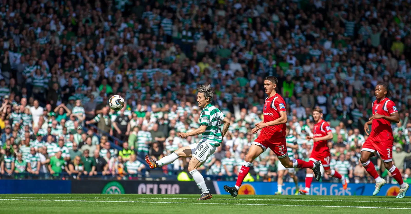 Daizen Maeda playing for Celtic during a match with the ball in the air.