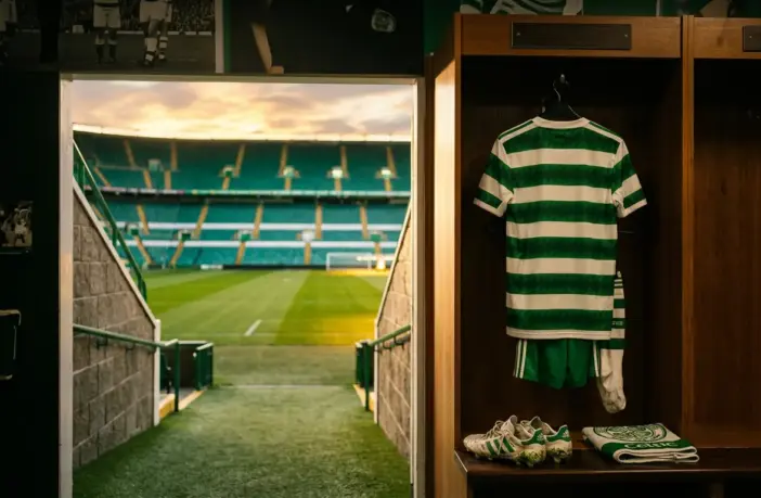 Celtic FC locker room with hoops jersey and view of Parkhead pitch symbolizing player transfers
