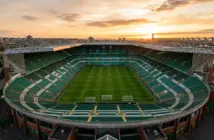 Celtic Park stadium bathed in golden light, showing empty stands and pitch from elevated view