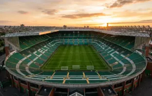 Celtic Park stadium bathed in golden light, showing empty stands and pitch from elevated view