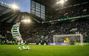 Celtic penalty kick moment under floodlights with tense crowd atmosphere at Scottish football stadium