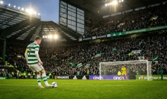 Celtic penalty kick moment under floodlights with tense crowd atmosphere at Scottish football stadium