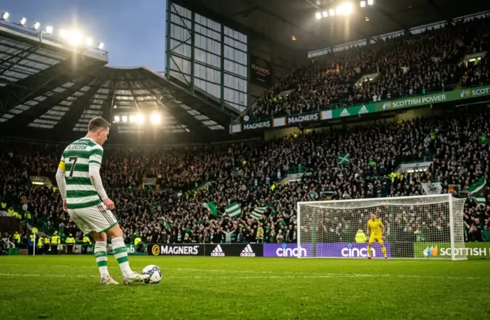 Celtic penalty kick moment under floodlights with tense crowd atmosphere at Scottish football stadium