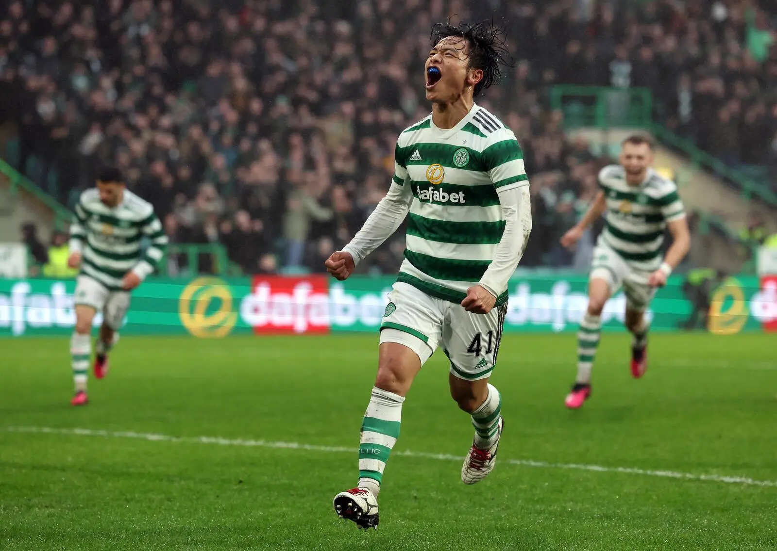 Reo Hatate celebrates scoring for Celtic during a match.