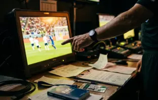 Referee reviewing VAR monitor during match controversy investigation