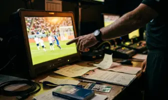 Referee reviewing VAR monitor during match controversy investigation