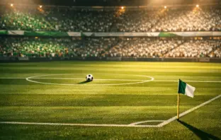 Floodlit stadium pitch with Algeria national colours in spotlight, ball on halfway line, dramatic evening atmosphere.