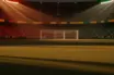 Floodlit stadium at golden hour with packed stands, dramatic shadows, and red-gold and green-gold lighting reflecting Belgium vs. Senegal colours.