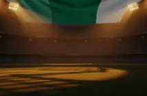 Floodlit World Cup stadium at sunset with packed stands and dramatic golden-hour lighting on empty grass pitch.