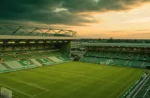 Celtic Park stadium illuminated on summer evening with lush green pitch under golden hour lighting