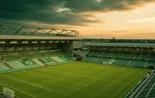 Celtic Park stadium illuminated on summer evening with lush green pitch under golden hour lighting