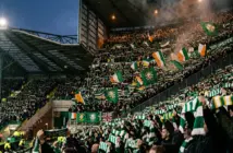 Celtic supporters holding scarves aloft in unity at Celtic Park stadium