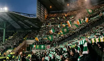 Celtic supporters holding scarves aloft in unity at Celtic Park stadium