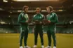 Celtic coaching staff on sideline at Celtic Park in green training kit discussing tactics
