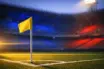 Empty stadium corner with blue-and-red flag-coloured floodlighting, corner flag sharp in foreground, golden dusk light across tiered seating.