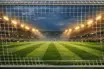 Illuminated women's football stadium pitch under floodlights awaiting crucial derby match