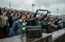 Vintage transistor radio on football terrace with Celtic supporters in background, May 1986