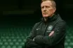 Celtic manager standing in stadium with determined expression, ready for new season challenge