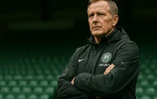 Celtic manager standing in stadium with determined expression, ready for new season challenge