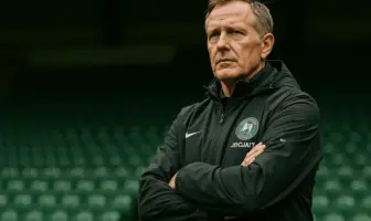 Celtic manager standing in stadium with determined expression, ready for new season challenge