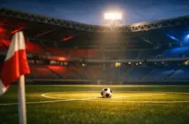Floodlit empty football pitch at dusk with Panama flag-coloured lighting accents, ball on centre spot, dramatic shadows.