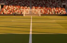 Floodlit football stadium at golden-hour with packed stands, empty pitch, red-white and gold-green crowd colours.