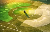 Abstract aerial pitch view with Saudi Arabian flag colours, tactical overlays, and centre-circle football at golden hour.